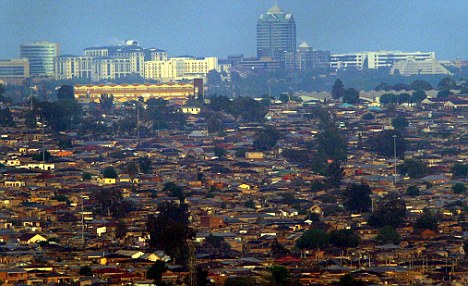A view of the towers of Sandton City above the slums of Alexandra Township, Johannesburg